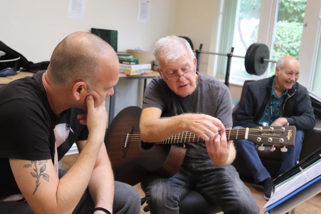 Veteran learning the guitar during RBVE's Step-In Programme