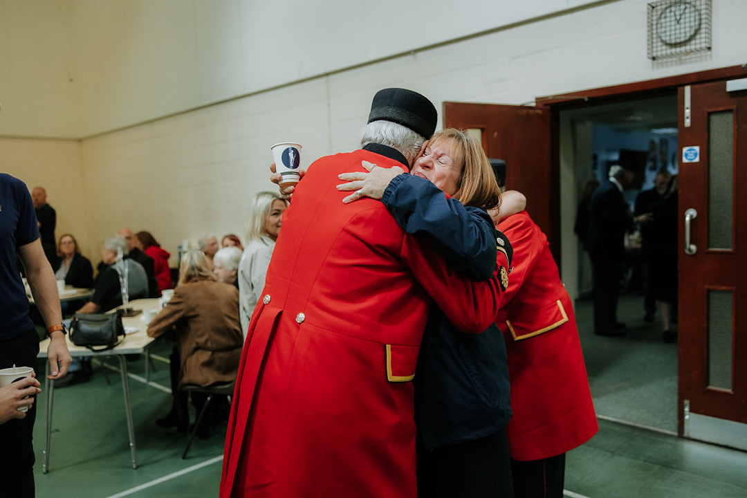 Veteran and member embracing and smiling at Tommy Club event