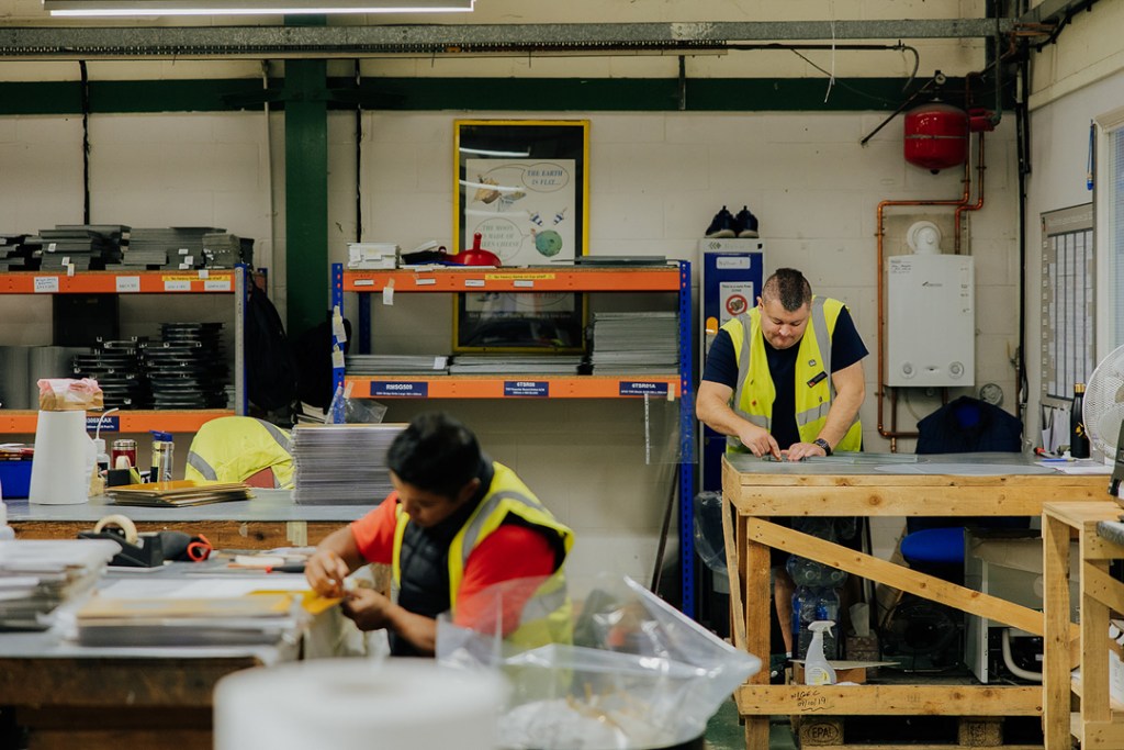 BBMC employees hard at working creating signs at work bench