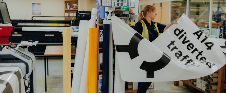 RBVE - BBMC worker carries a large sign for National Highways