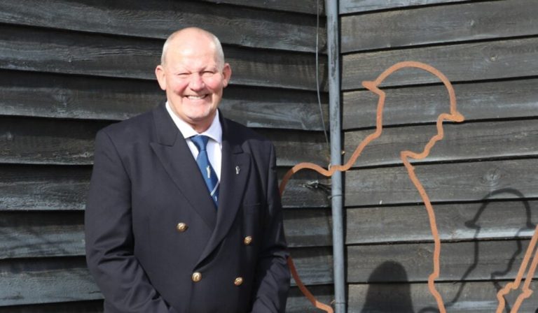 Veteran Steve Hammond standing next to a Tommy statue